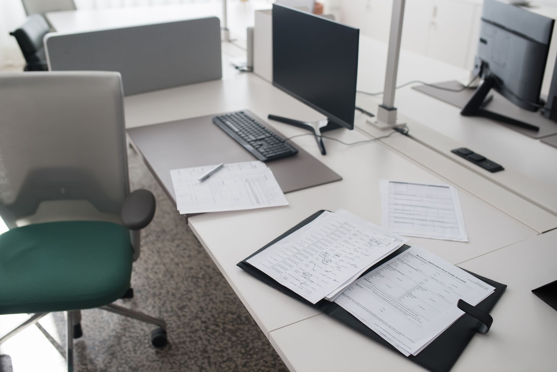 Documents administratifs et ordinateur posés sur un bureau de travail