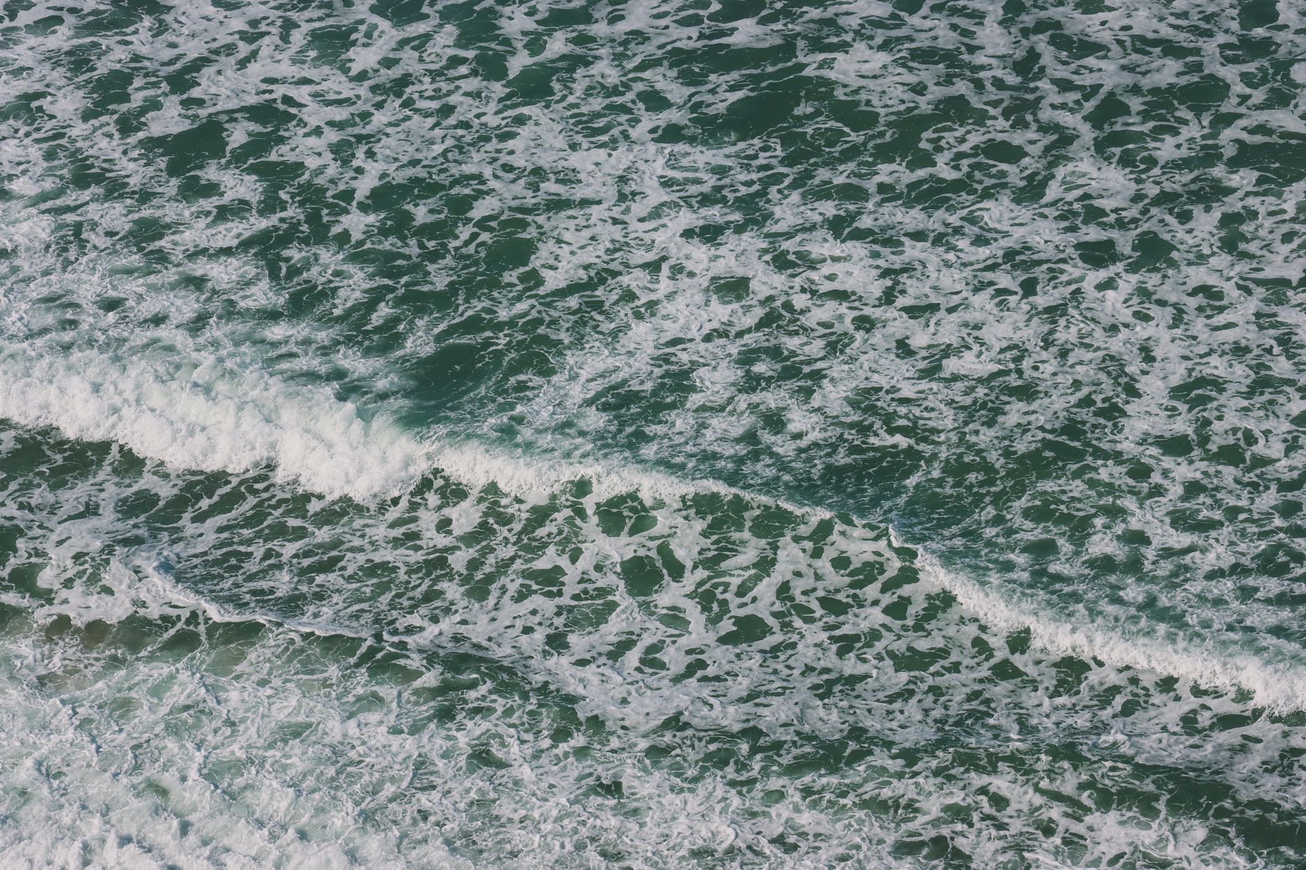 Stunning aerial view capturing the frothy waves of the Pacific Ocean near San Diego, California.