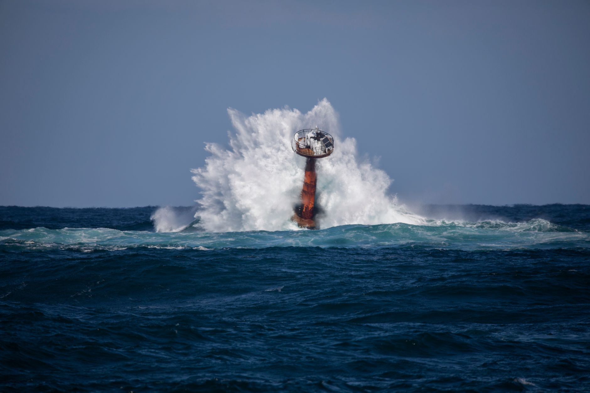 Powerful ocean waves crash against a buoy off the coast of Goseong, South Korea, showcasing nature's force.