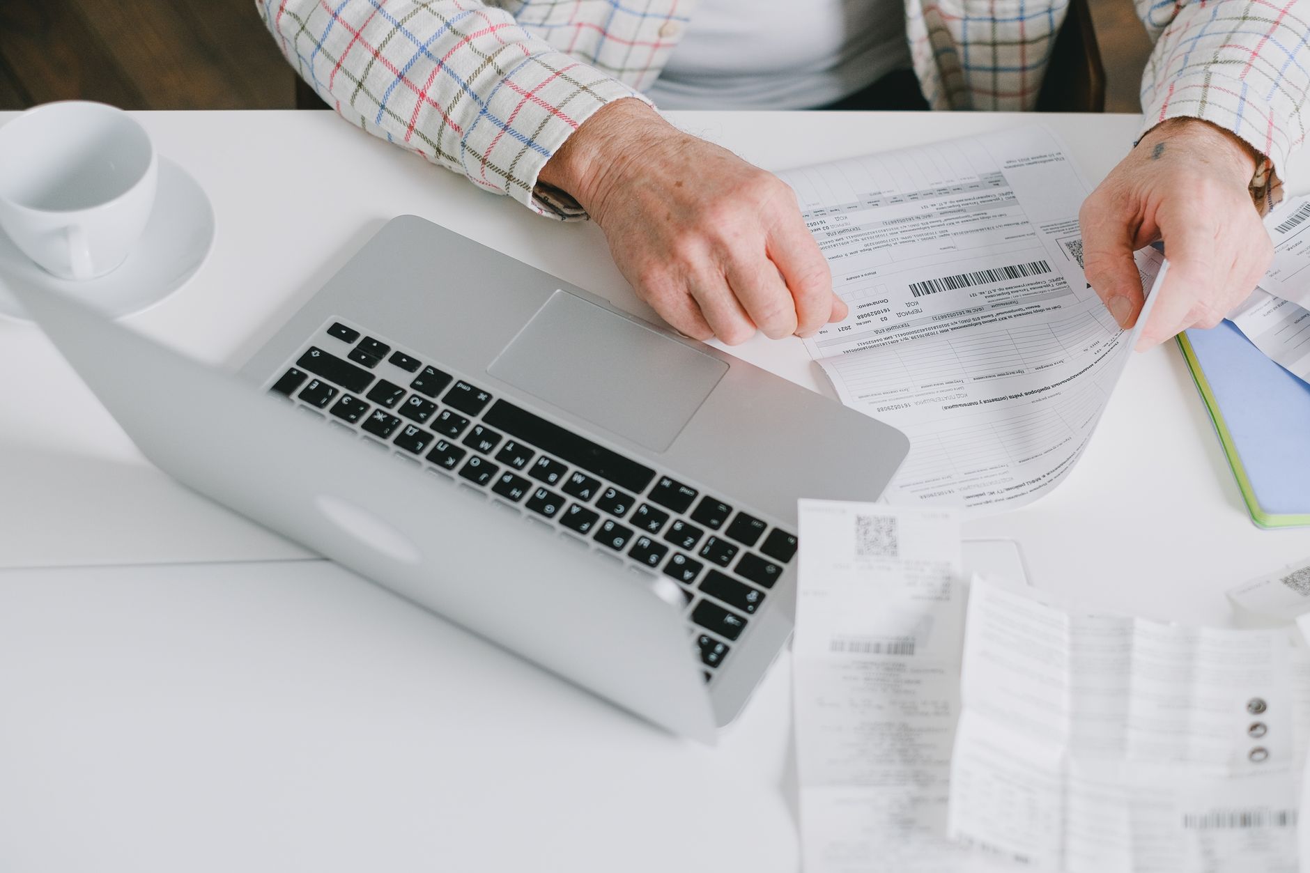 Documents de facturation et calculatrice posés sur un bureau