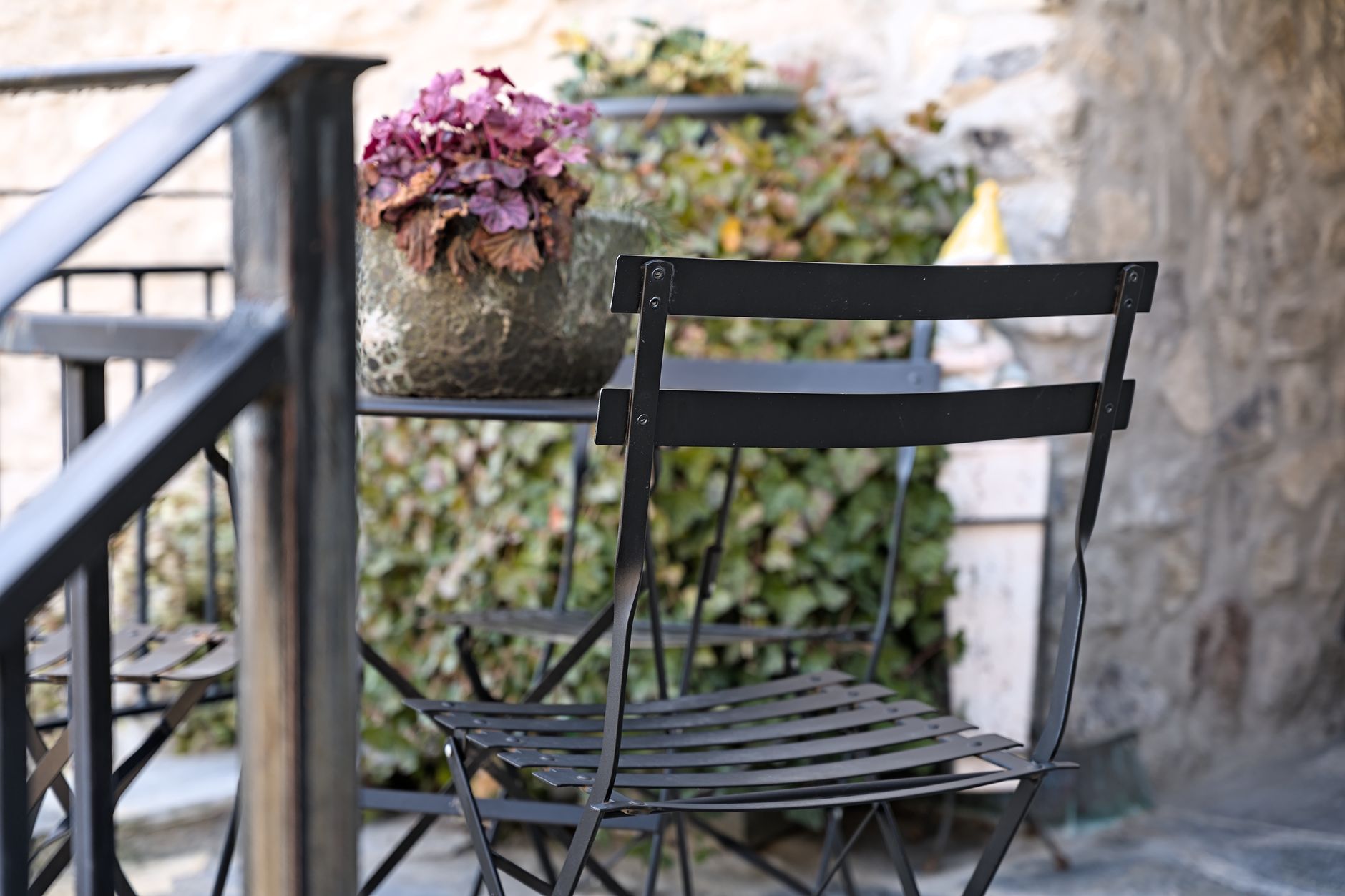 Chaise de terrasse en métal noir devant des jardinières
