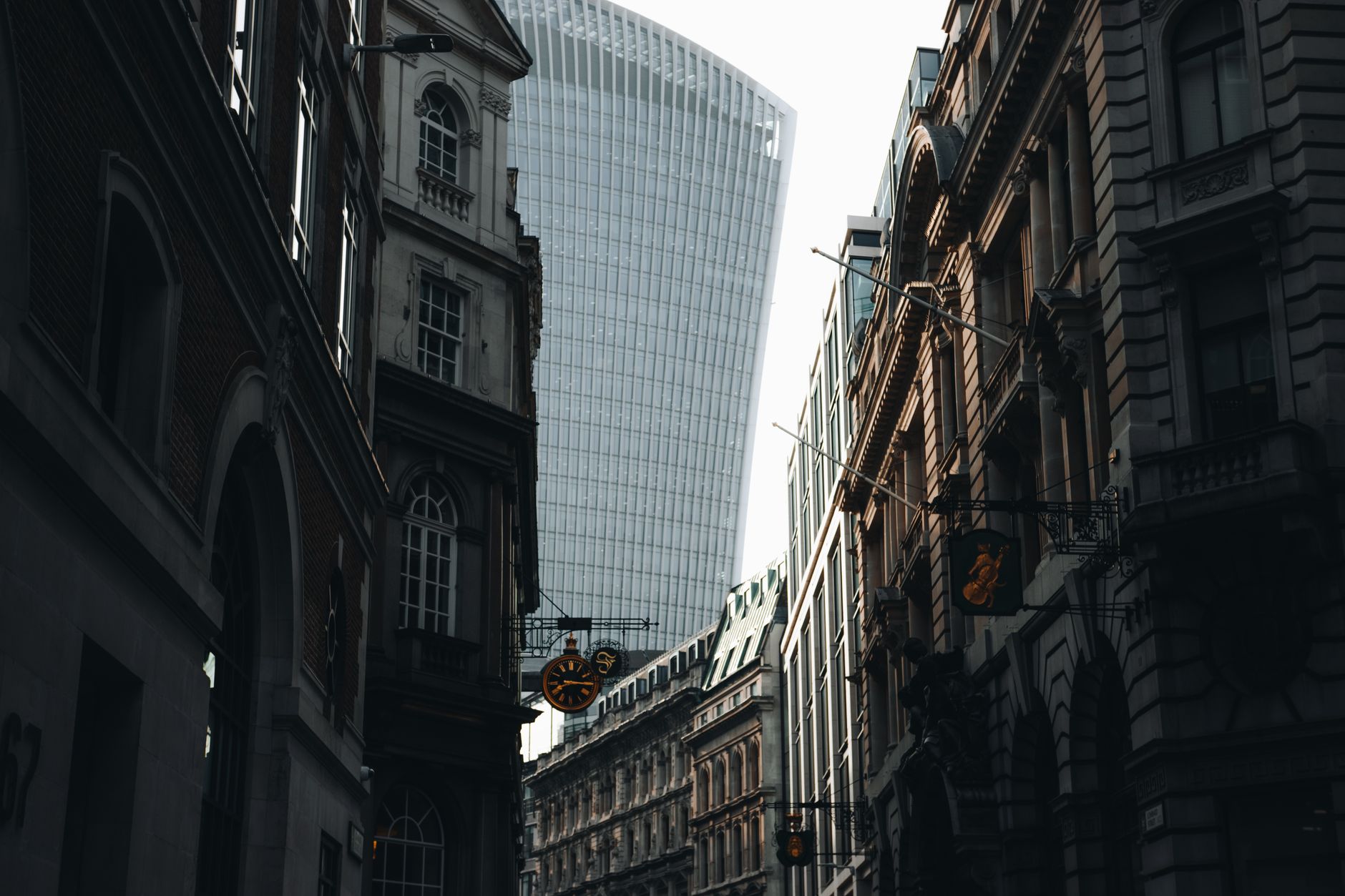 A stunning view of London's famous skyscraper amid historic architectural facades in the financial district.