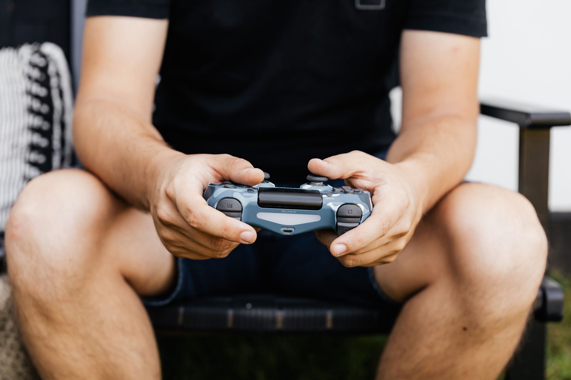 Close-up of hands holding a wireless gaming controller, perfect for tech enthusiasts.