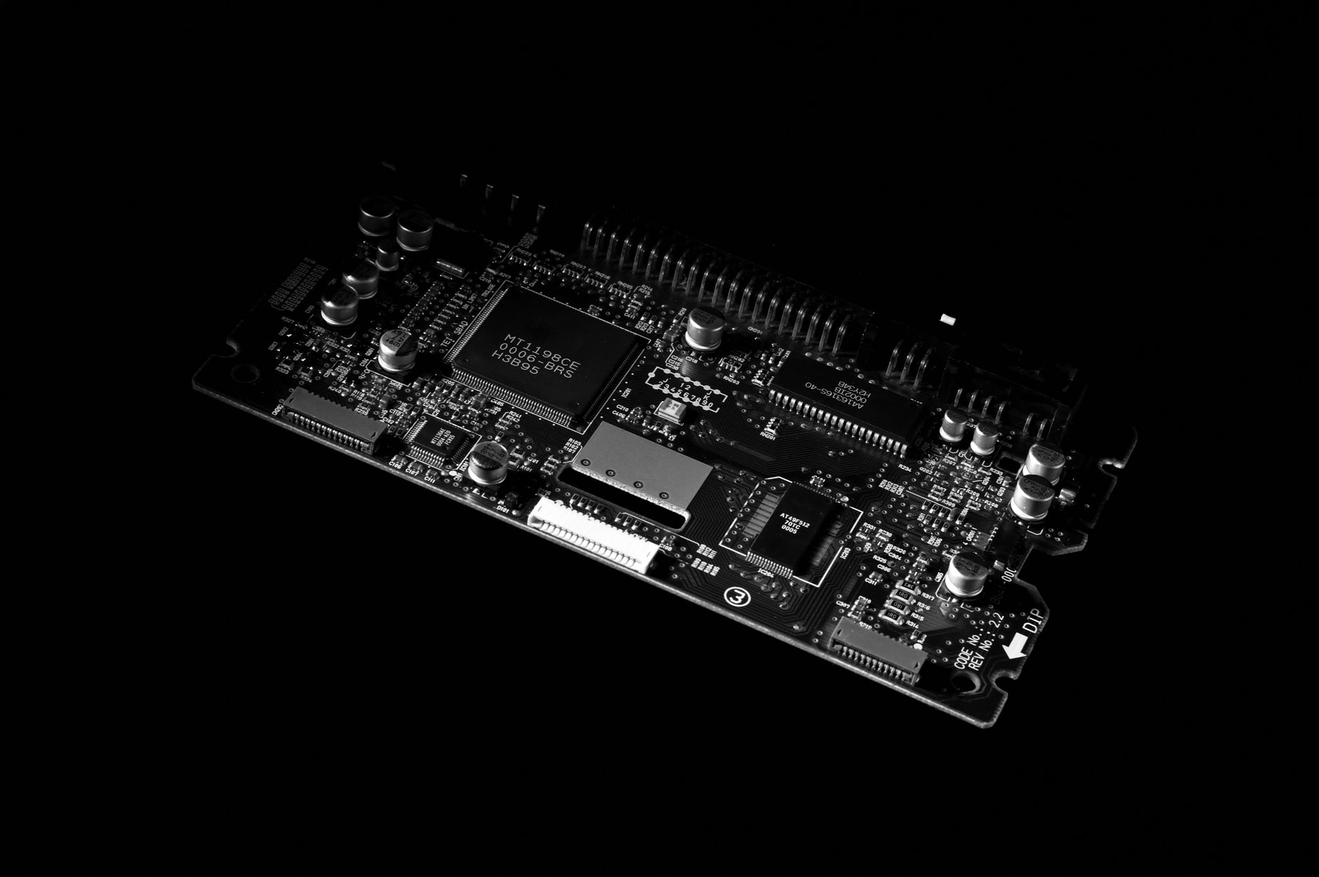 Detailed black and white image of a computer circuit board, showcasing technology components.