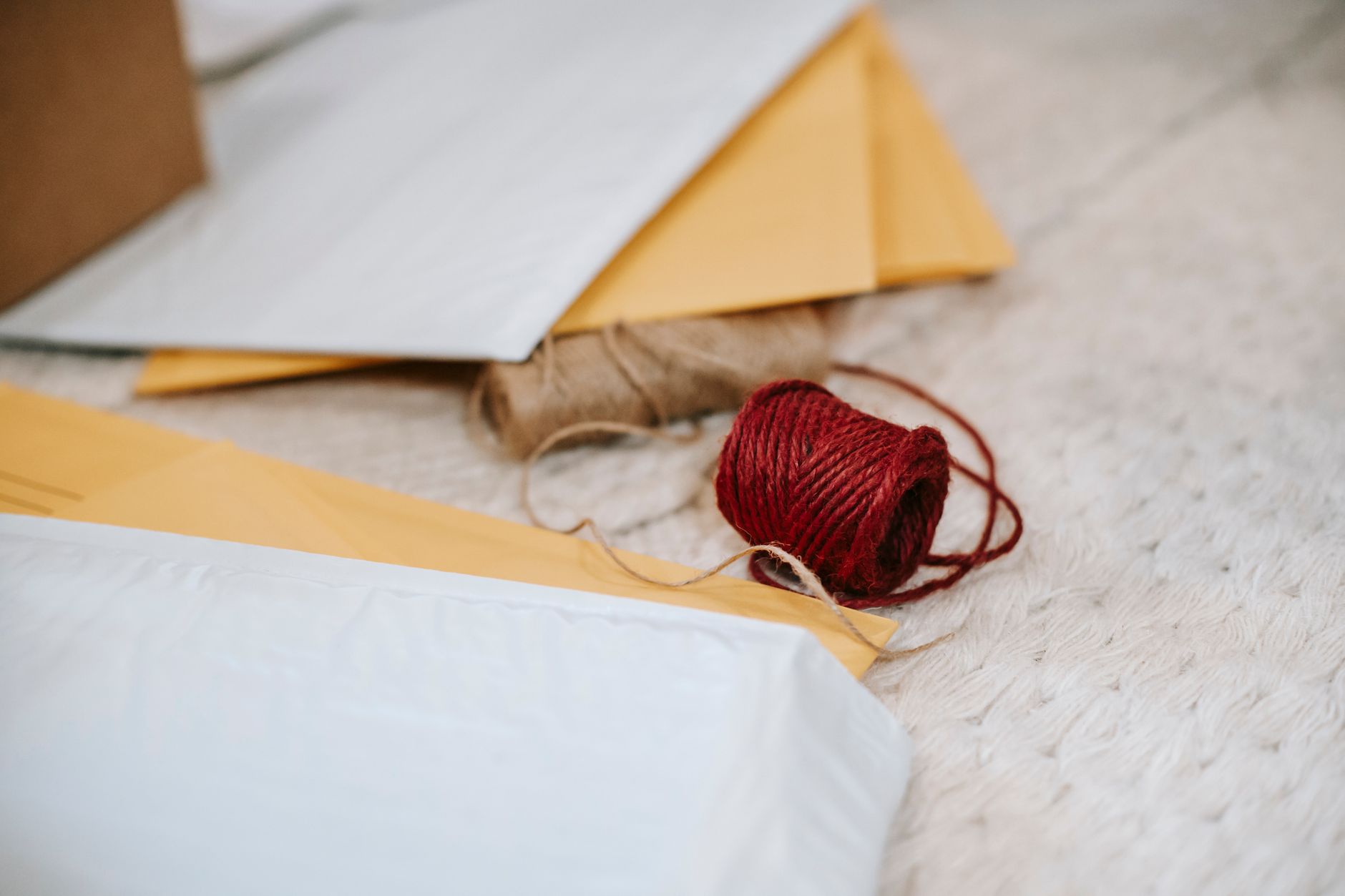 Thick woolen threads placed among paper envelopes for sending mail on textured textile