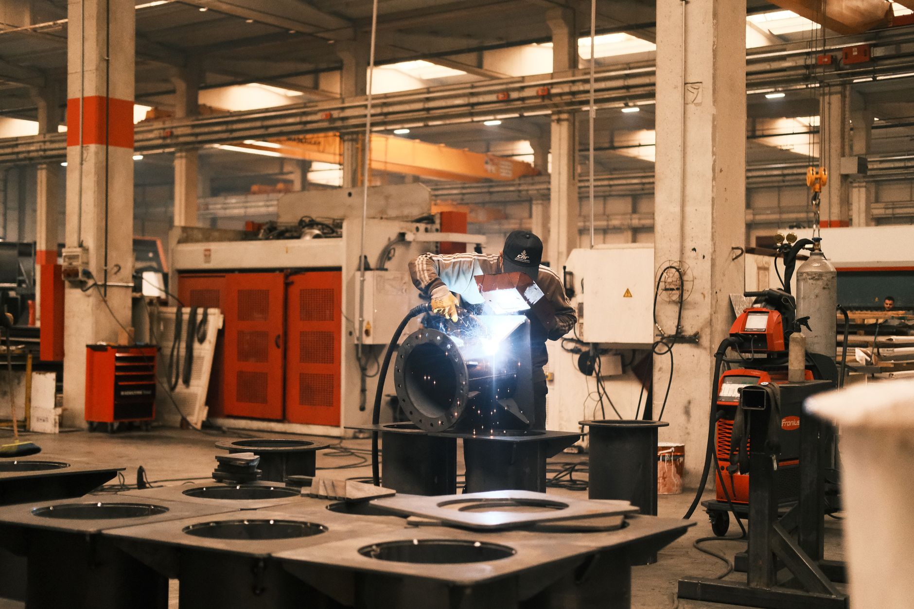 A welder working on metal components in an industrial factory in Konya, Türkiye.