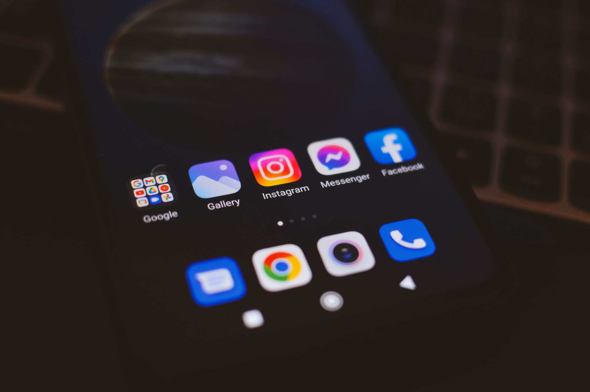 A smartphone displaying popular social media apps in a dimly lit environment, perfect for tech and communication themes.