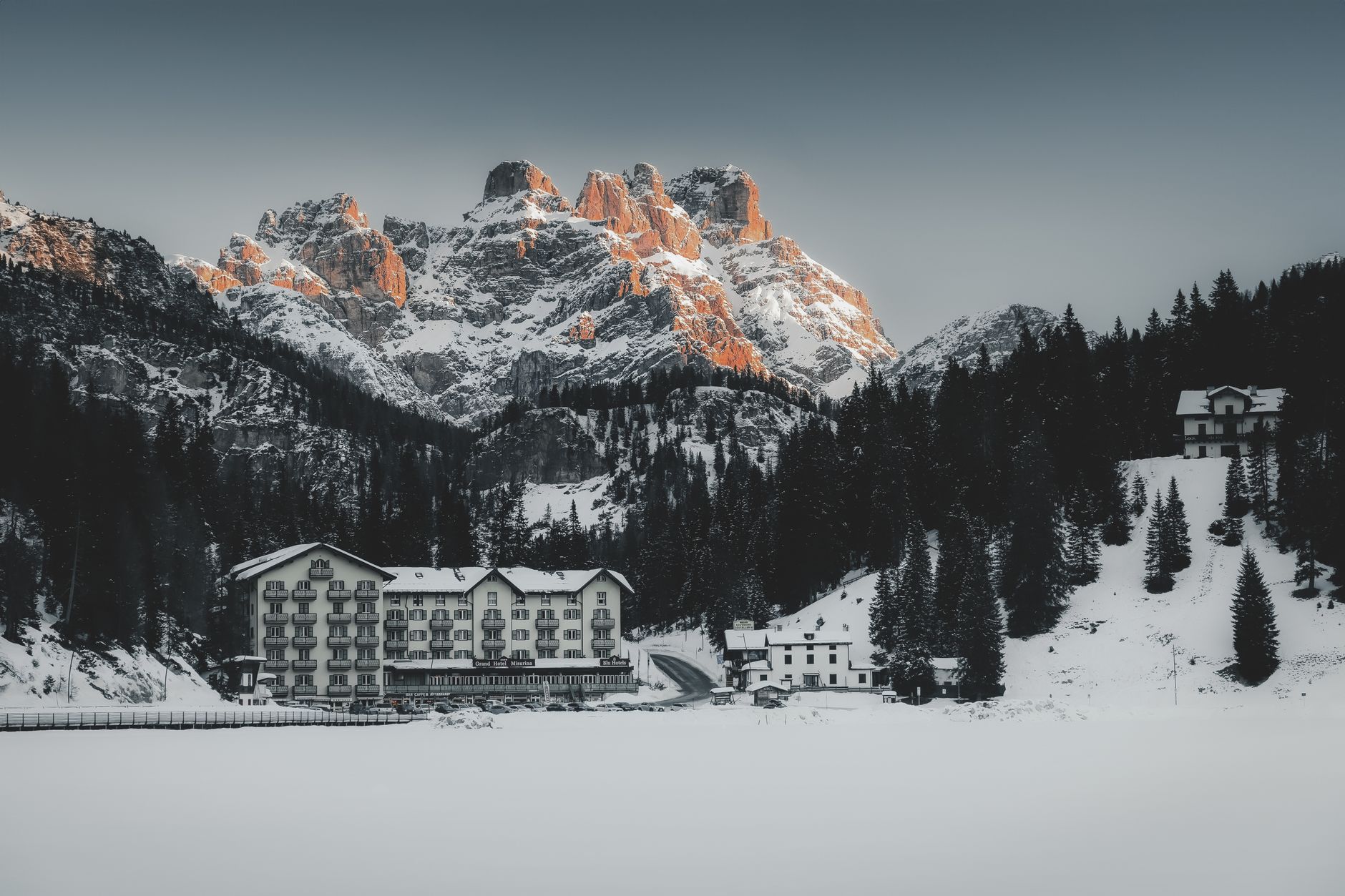 Stunning snowy alpine village at the foot of majestic mountains during winter.
