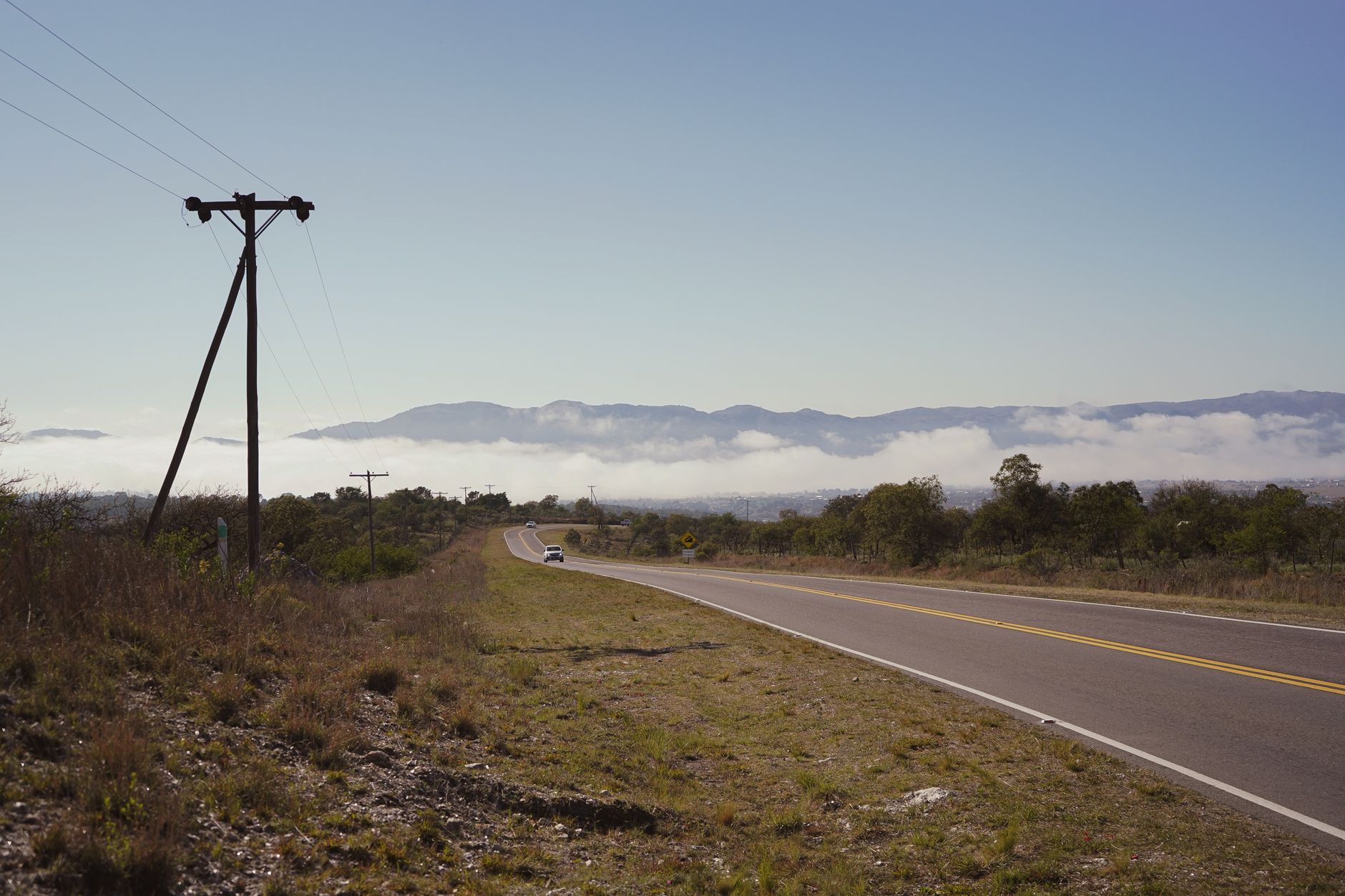A serene rural road with hills in the background in Villa Yacanto, Córdoba, Argentina.