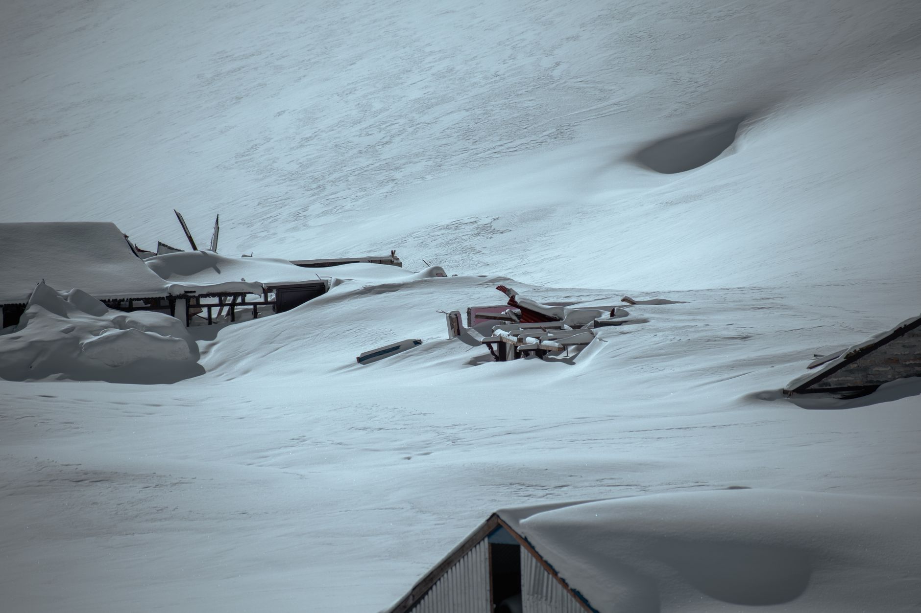 A serene view of snow-covered buildings at a ski resort, showcasing winter's beauty.