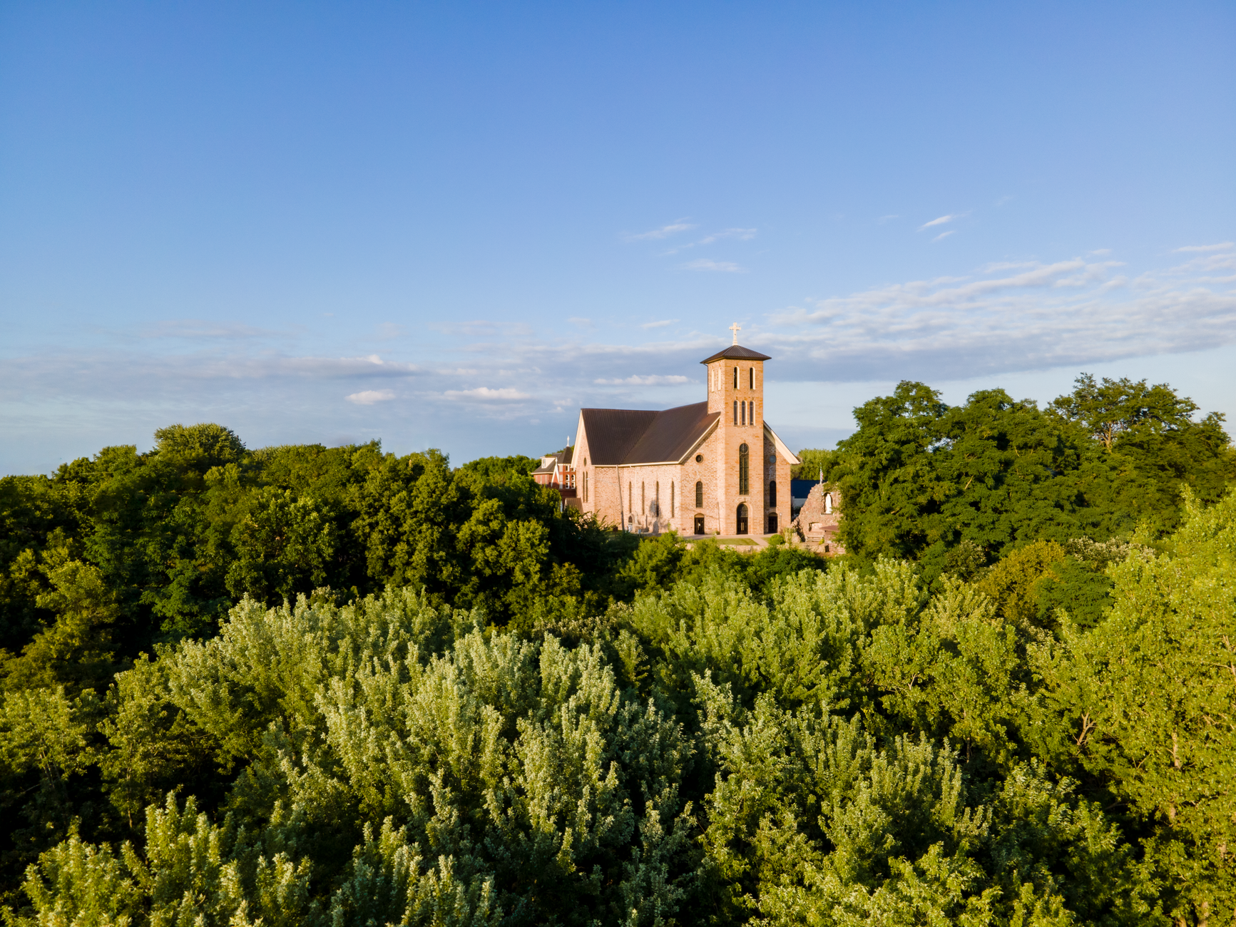 Scenic aerial photo of a historic church surrounded by lush greenery in Eau Claire, WI.