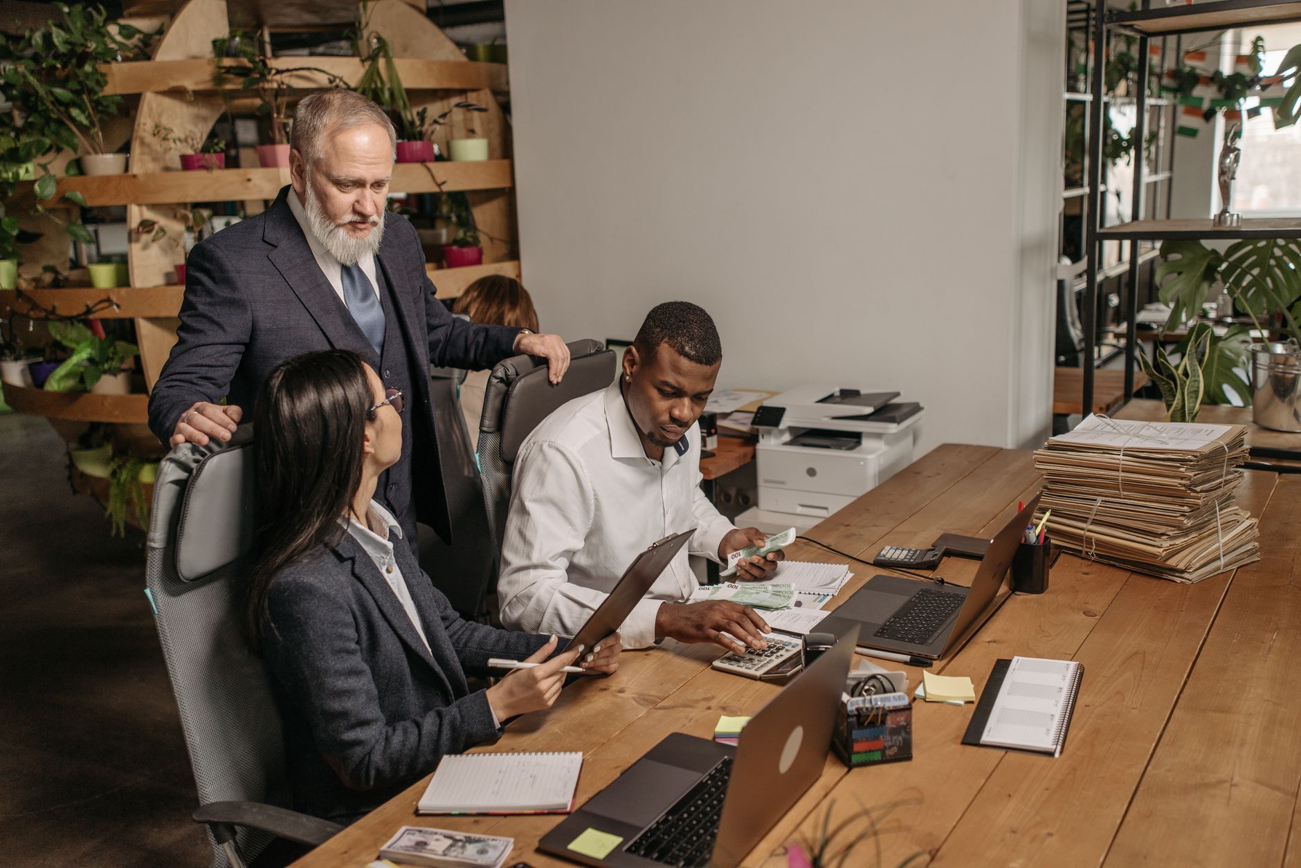 A diverse team of professionals collaborating in a modern office setting, focused on documents.