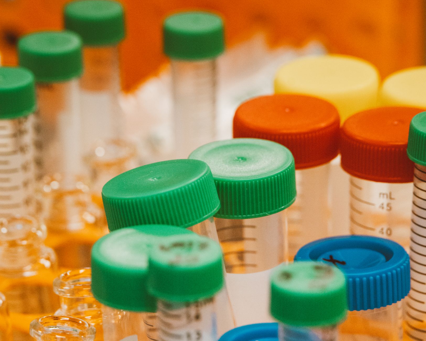 Close-up of colorful laboratory sample bottles with caps, showcasing scientific equipment.