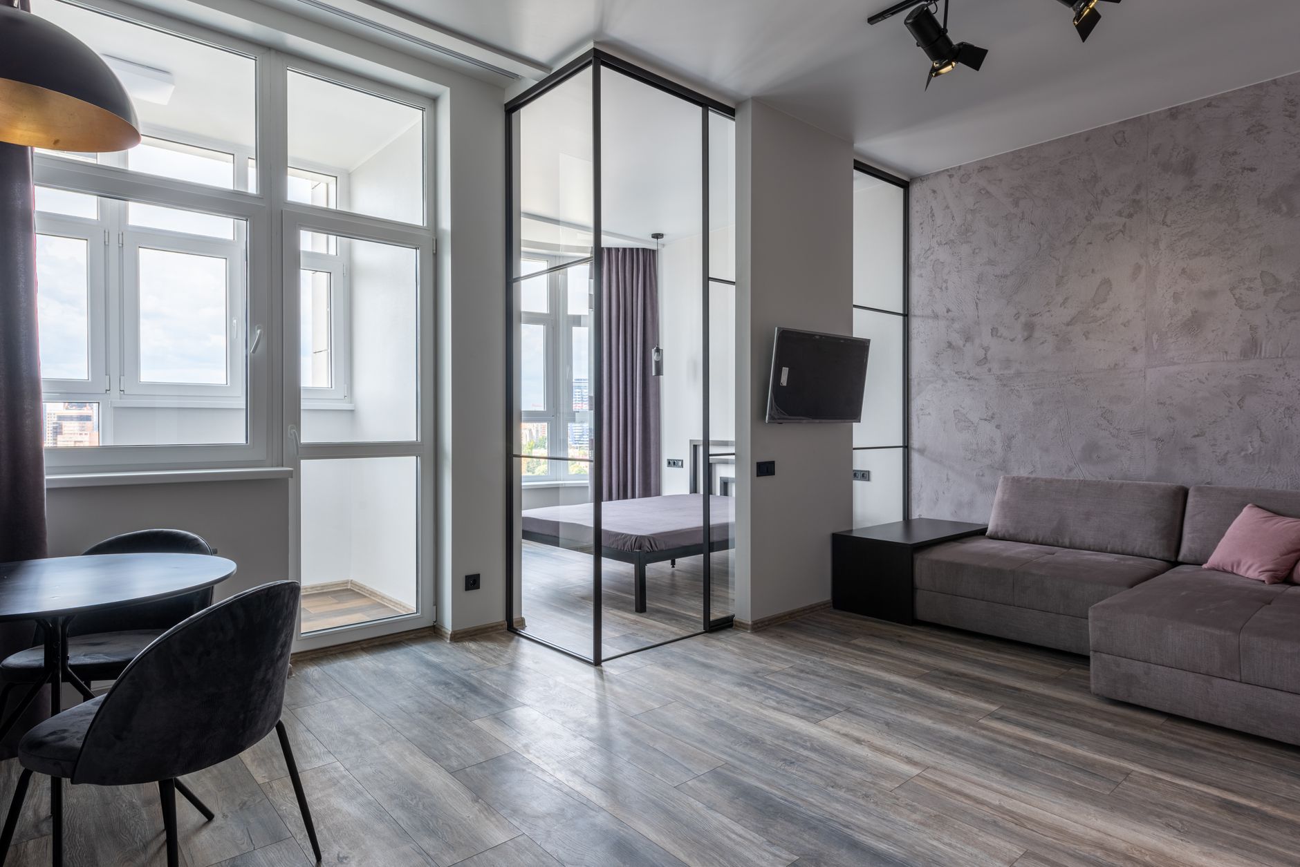 Creative design of room interior with chairs and table against sofa on floor and television set on wall