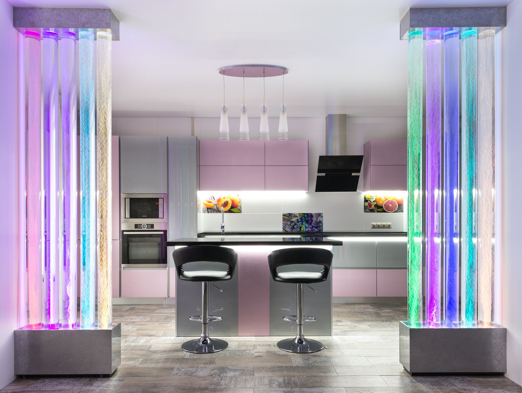 Interior of contemporary kitchen with table and chairs placed near colorful cupboards with modern kitchenware in stylish apartment with decorative bright bubble walls