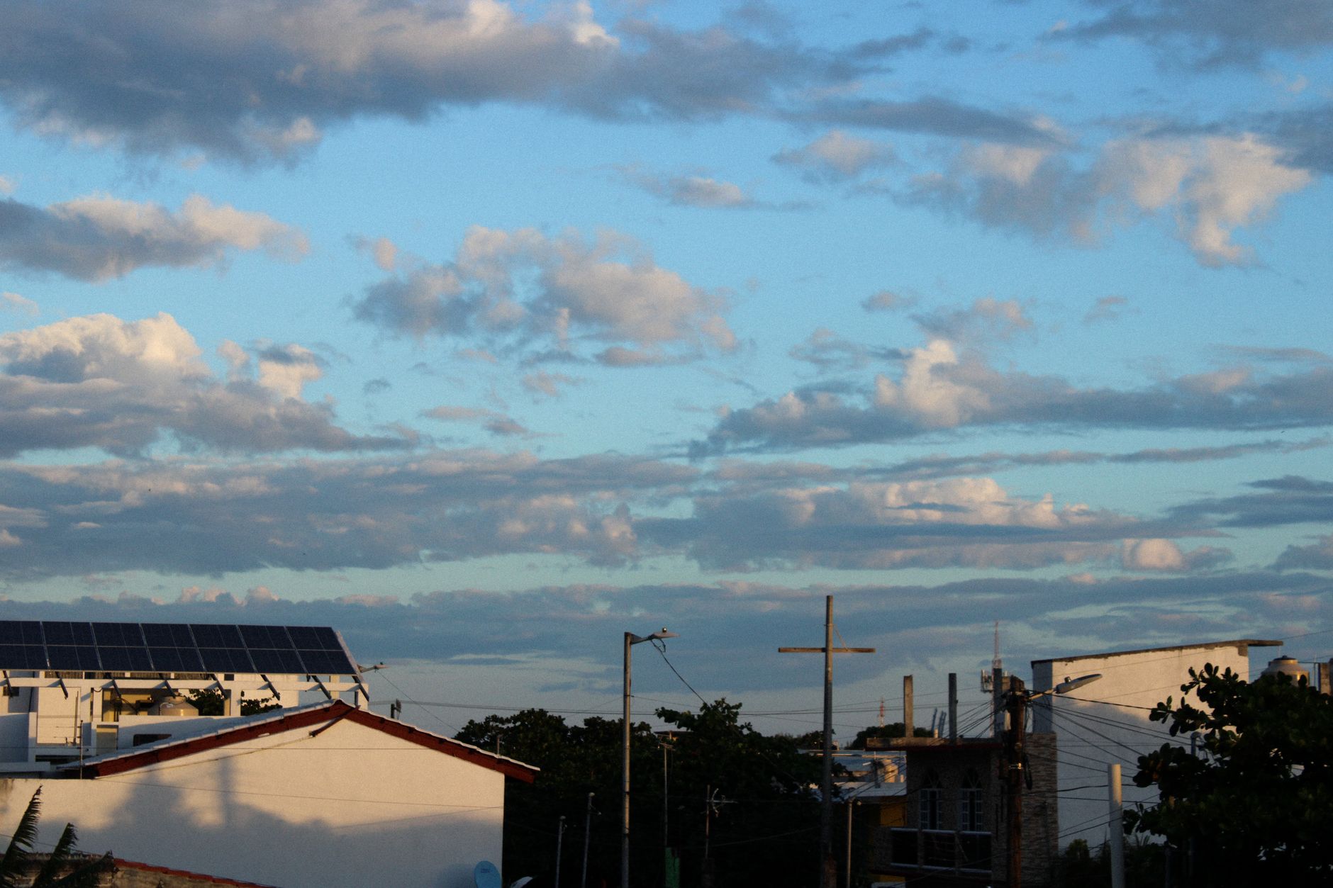Solar panels and electricity transmission lines near sunset
