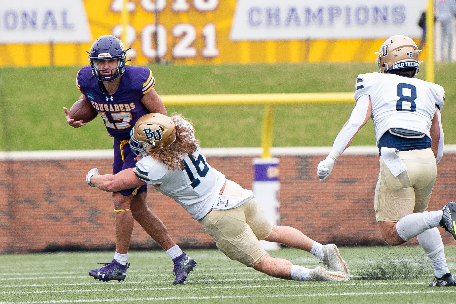 Action shot of a college football game with players in motion on the field.