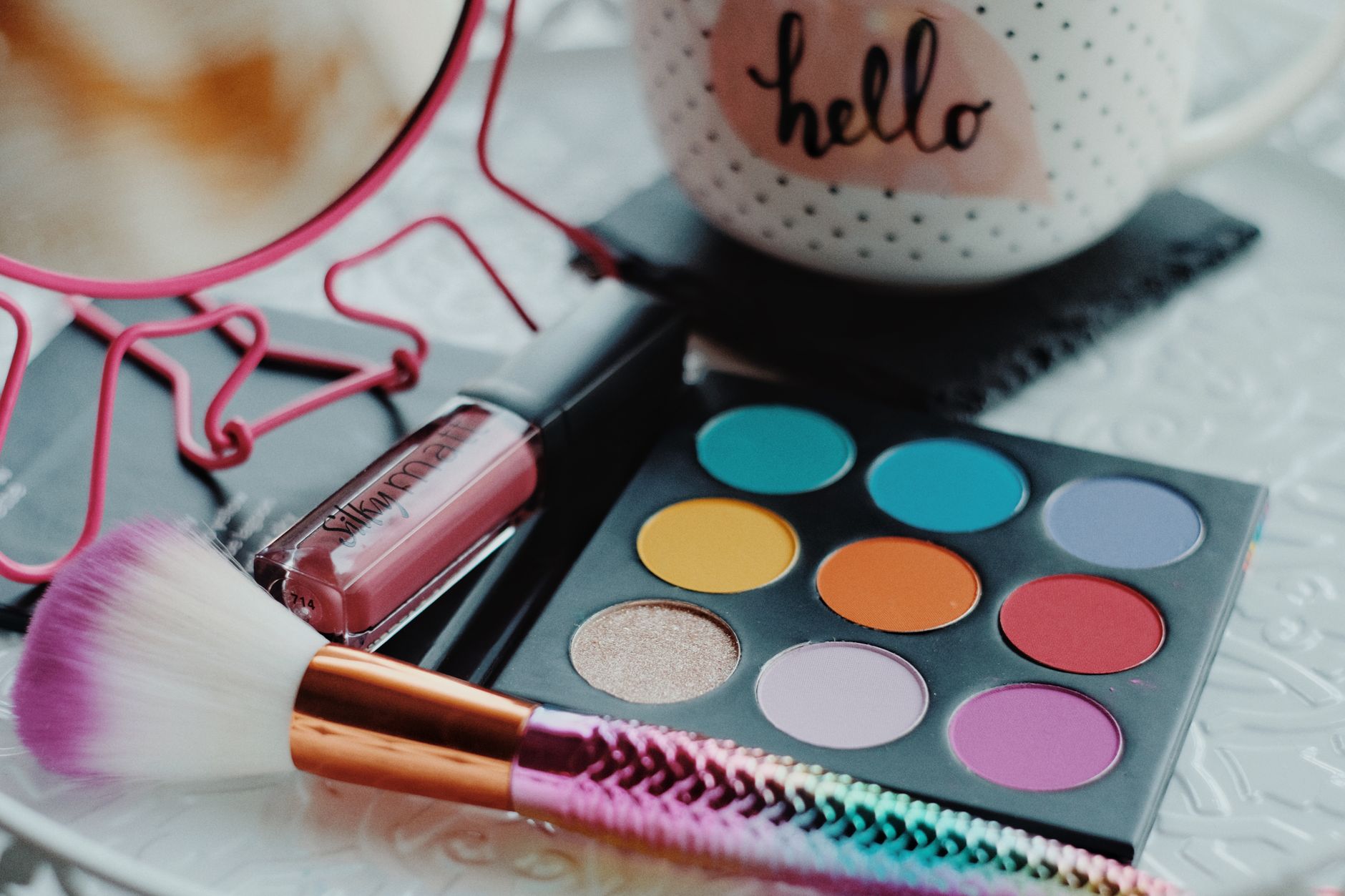 Vibrant eyeshadow palette with lipstick and brush, perfect for beauty enthusiasts.
