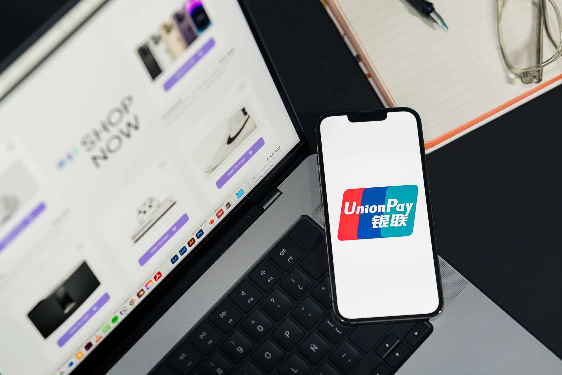 Main tenant un smartphone près d’un terminal de paiement