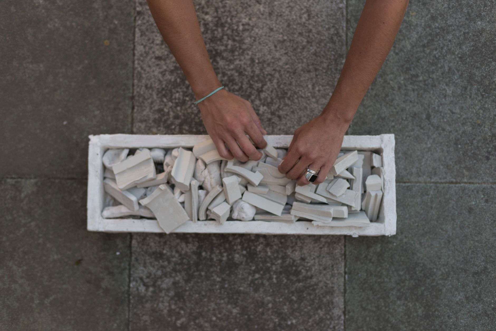 Mains d’un artisan travaillant une pièce de pierre avec des outils manuels