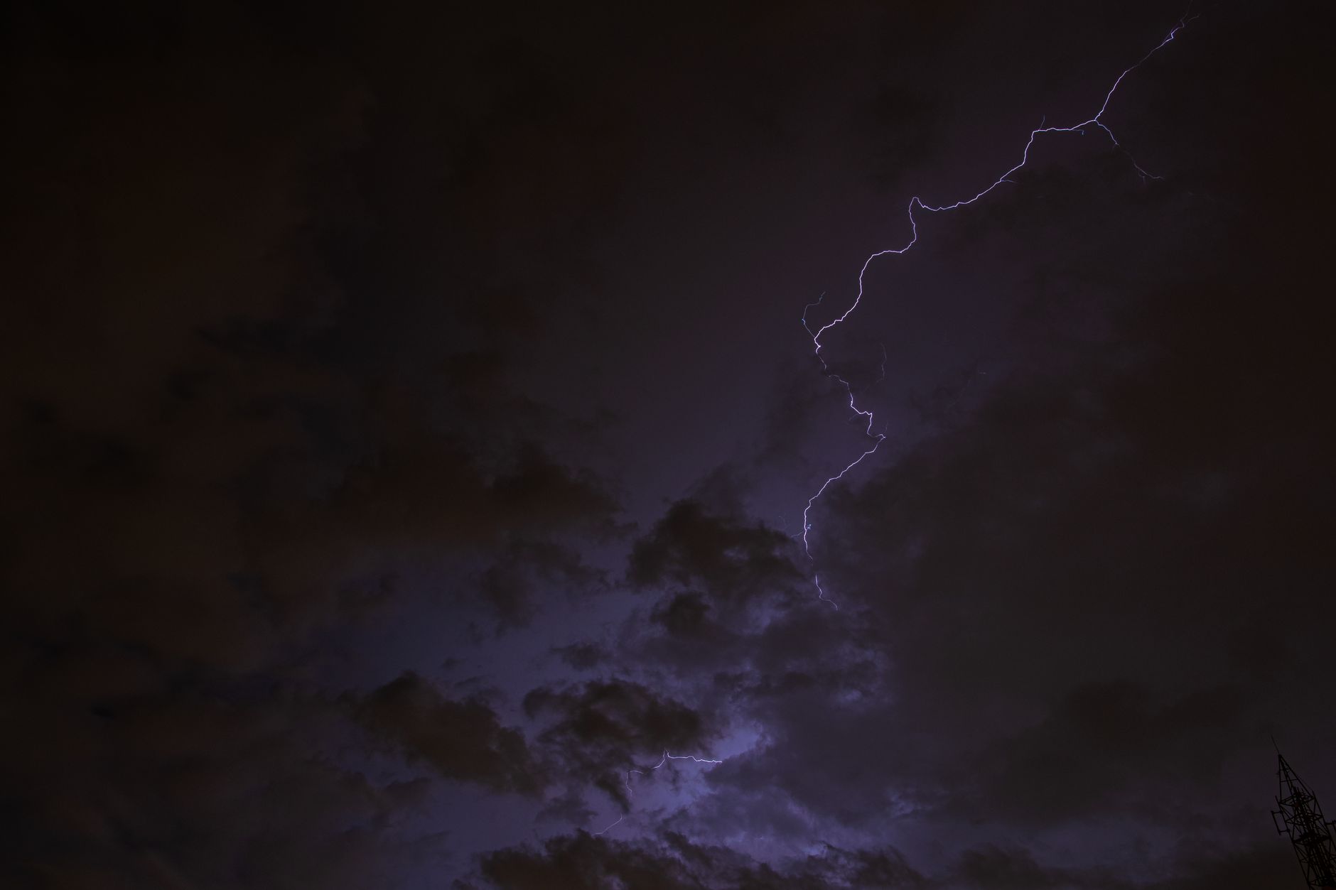 Dramatic night sky with vivid lightning streaks and dark clouds highlighting a natural storm.
